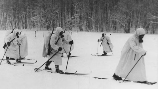 Finnish soldiers wearing gas masks and travelling using skis during the Winter War